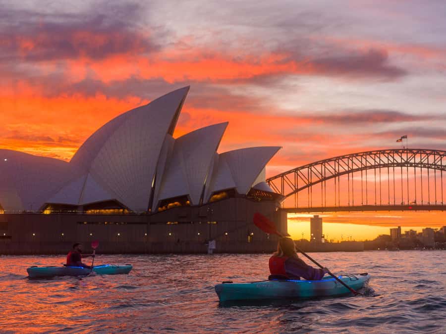 Kayakers on Sydney Harbour at first light, the bridge and the Opera House behind them